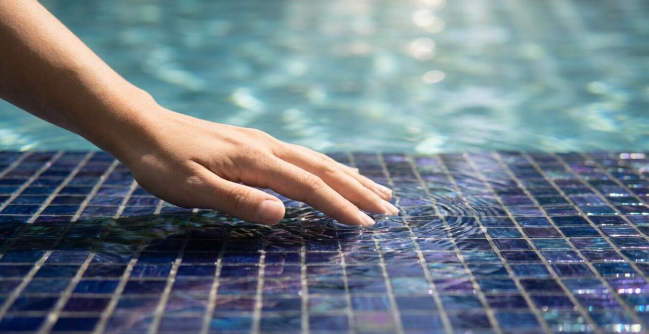 Dark blue glass mosaic tiles underwater showing pristine condition without scale