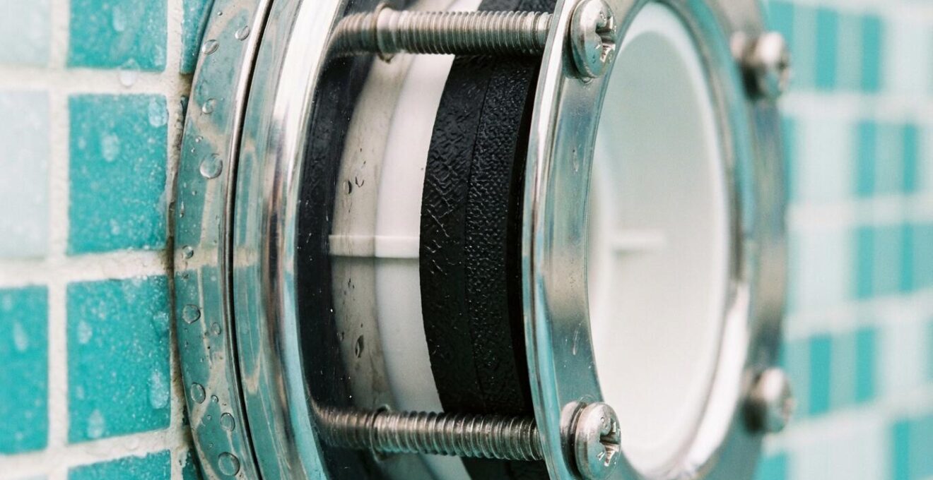 Close-up view of pool light gasket installation showing star pattern tightening sequence